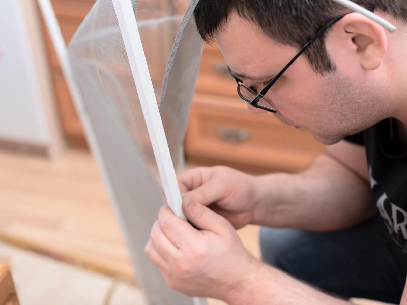 man-repairing-mosquito-net-at-home-home-improvement-concept-.jpg